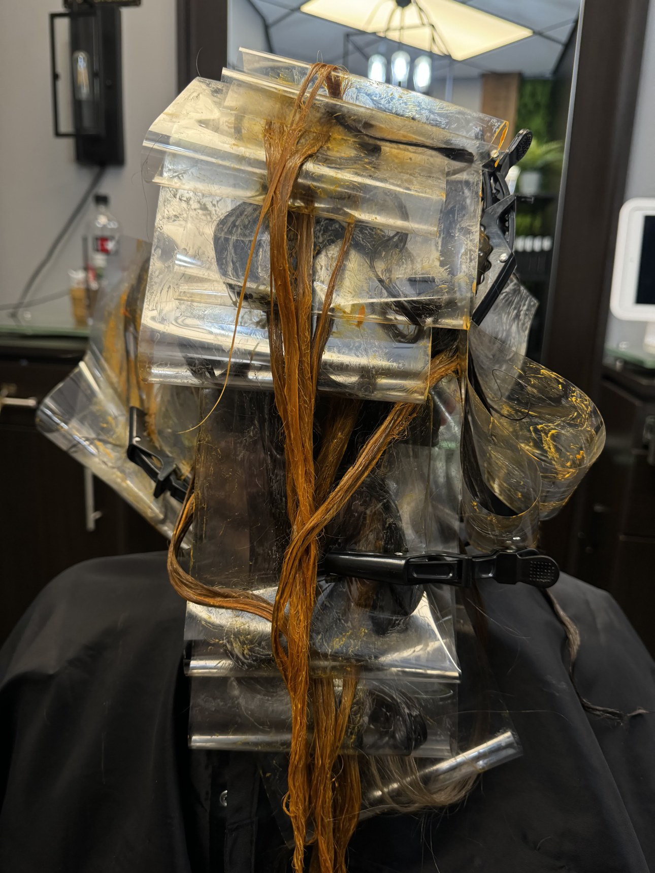 Reverse balayage in progress at CRIS HAIR: lowlights being painted and wrapped to deposit depth back into over-lightened hair