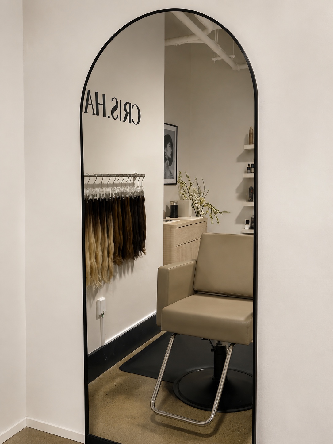 Arched mirror reflecting the calm interior of the CRIS HAIR studio